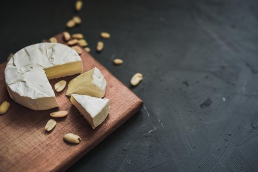 cheese camembert with mold and nuts on the wooden cutting board