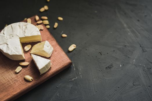 cheese camembert with mold and nuts on the wooden cutting board