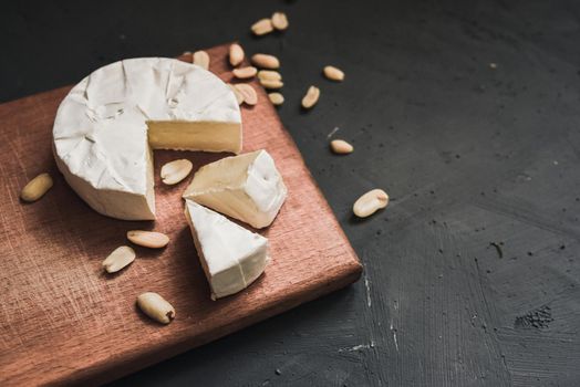 cheese camembert with mold and nuts on the wooden cutting board