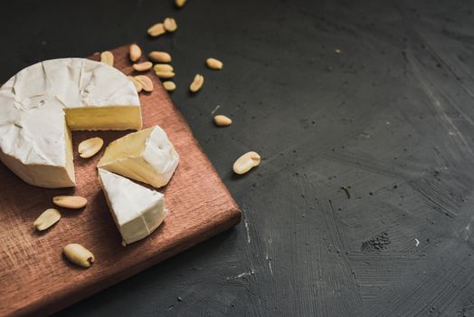 cheese camembert with mold and nuts on the wooden cutting board