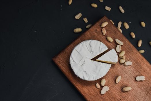 cheese camembert with mold and nuts on the wooden cutting board