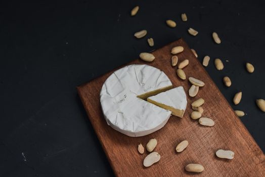 cheese camembert with mold and nuts on the wooden cutting board