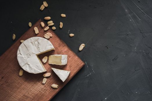 cheese camembert with mold and nuts on the wooden cutting board