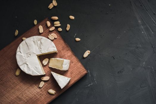 cheese camembert with mold and nuts on the wooden cutting board