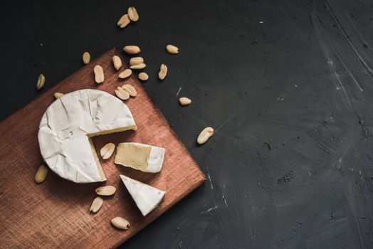 cheese camembert with mold and nuts on the wooden cutting board