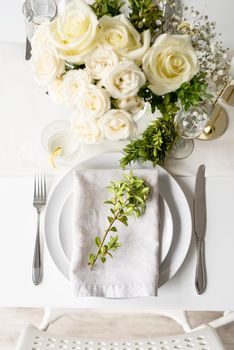 Wedding table set up in taditional style with roses and greenery. Wedding table scapes, top view table setting