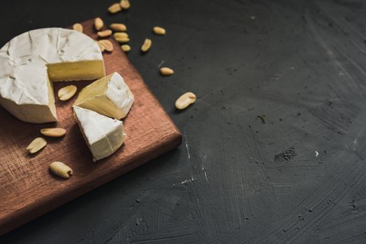 cheese camembert with mold and nuts on the wooden cutting board