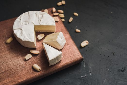 cheese camembert with mold and nuts on the wooden cutting board