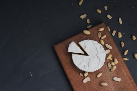 cheese camembert with mold and nuts on the wooden cutting board