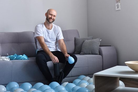 Celebration, holidays, party concept. Happy hairless man preparing to party. Blowing blue and white balloons