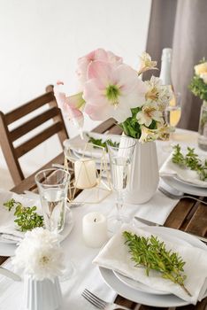 The wedding table setting and decor on wooden table in rustic style. Wedding table scapes. Table set up with boxwood and amaryllis flowers