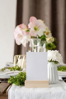 The wedding table setting and decor on wooden table in rustic style. Wedding table scapes. Table set up with boxwood and amaryllis flowers. mockup table number