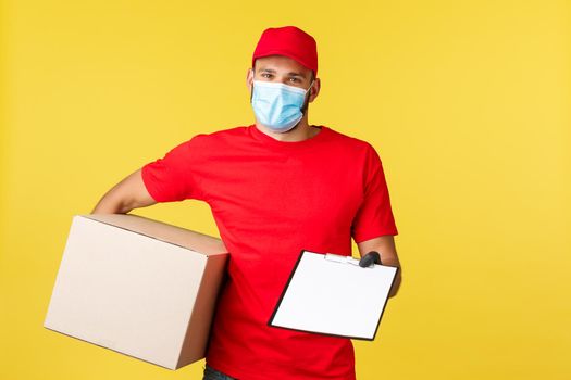 Express delivery during pandemic, covid-19, safe shipping, shopping concept. Friendly courier bring parcel to client, giving clipboard with form to sign, wearing protective medical mask and gloves.