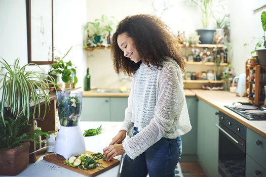 Beautiful african woman making a smoothie for breakfast. High quality photo