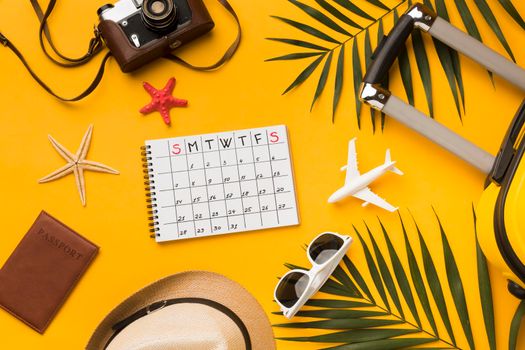 flat lay travel essentials with calendar sunglasses