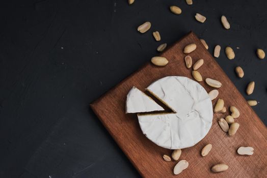 cheese camembert with mold and nuts on the wooden cutting board