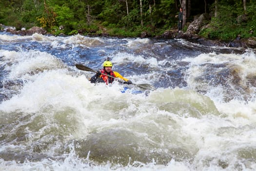 Kayaker in the whitewater on a river in Republic of Karelia, Russia