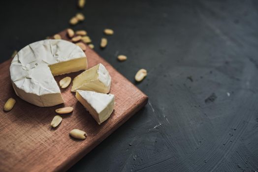 cheese camembert with mold and nuts on the wooden cutting board