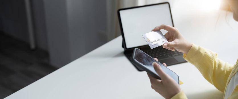 Close up of girl hold bank credit card, shopping online using mobile phone, buying goods or ordering online, entering bank accounts and details in online banking offer