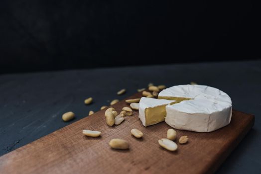 cheese camembert with mold and nuts on the wooden cutting board