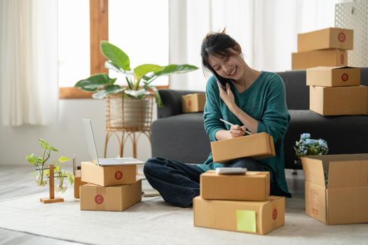 Starting Small business entrepreneur freelance, Portrait young woman working at home office, BOX, smartphone, laptop, online, marketing, packaging, delivery, b2b, SME, e-commerce concept.