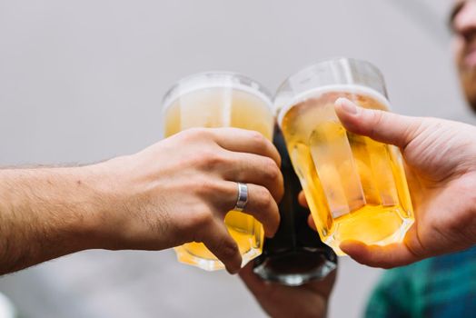 friend s hand toasting glass beer