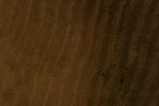 Aerial view from above. wavy field. brown earth. texture background.