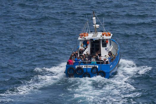 Martin's Haven, Pembrokeshire, Wales - July 13, 2021: Boat filled with visitors departing from the small harbour of Martin's Haven in Pembrokeshire, Wales to visit Skomer Island