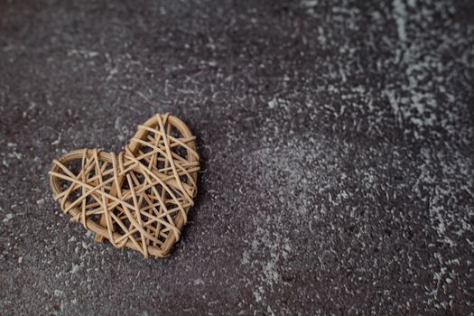 Wooden wicker heart on grunge background with copy space for love and Valentine's day concept
