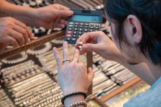 Guy tries on silver rings in india market, Goa