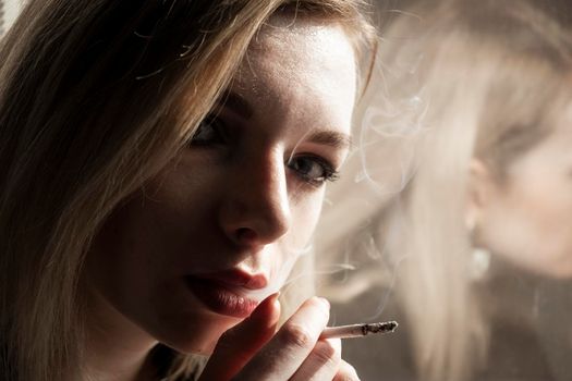 Close-Up Of Young Woman Smoking Cigarette By Window