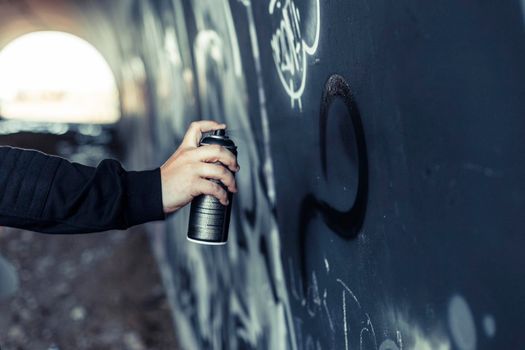 close up person s hand spraying paint with aerosol can graffiti wall