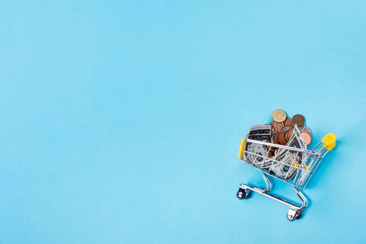 shopping cart filled with coins copy space background