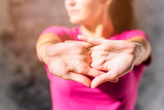 pretty sporty young woman stretching clasped hands