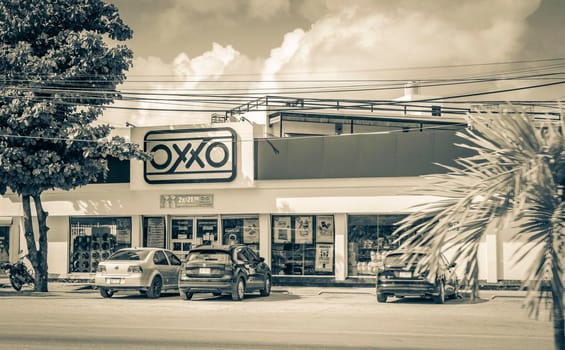 Tulum Mexico 02. February 2022 Old black and white picture of driving thru typical colorful street road and cityscape with cars traffic palm trees bars and restaurants of Tulum in Mexico.