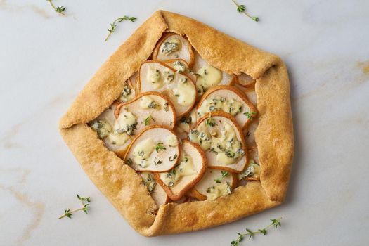 Pear galett with a blue cheese, savory pie, marble table, top view