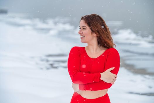 Caucasian red-haired woman posing in lingerie outdoors in winter