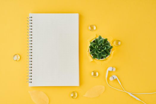 Blank notepad page in bullet journal on bright yellow office desktop. Top view of a modern bright table with notebook, minimalism. Mock up, copy space, concept for diary