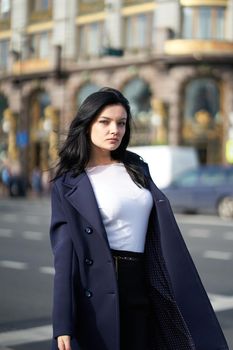 Portrait f beautiful intelligent brunette who walks down street of Saint-Petersburg in city center. Charming thoughtful woman with a long dark hair wanders alone, immersed in thoughts, copy space