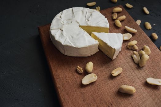 cheese camembert with mold and nuts on the wooden cutting board