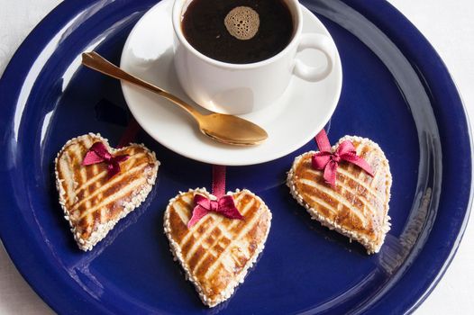 Cookies in the shape of heart on the blue plate with cap of cofee Retro style. From the series "Valentine's Day Cookies"