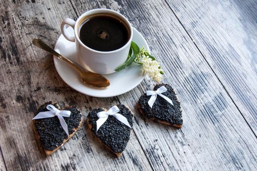 Cookies for the wedding decorated black sesame with a cup of coffee served with a golden spoon. From the series "Wedding Cookies"