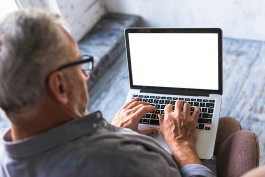 elevated view man using laptop with white blank screen