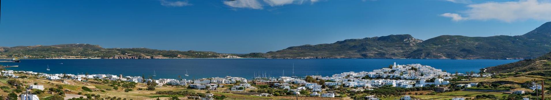 Panorama of Plaka village with traditional Greek church white painted Greek houses and ocean coast. Milos island, Greece