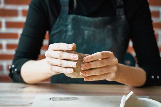 Unrecognisable Woman making pottery, hands closeup, blurred background, focus on potters, palms with pottery. Concept for woman in freelance, business, hobby. Turning hobbies into cash