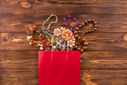 beads jewelry red paper bag wooden background