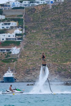 MYKONOS, GREECE - MAY 29, 2019: Man flying flyboarding on a Flyboard - hydroflighting device which supplies propulsion to drive the Flyboard invented by inventor Franky Zapata