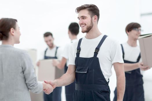 Manager with clipboard shaking hands with movers.