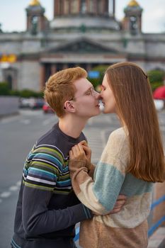 The boy looks tenderly at girl and wants to kiss. Concept of teenage love and first kiss, vertical