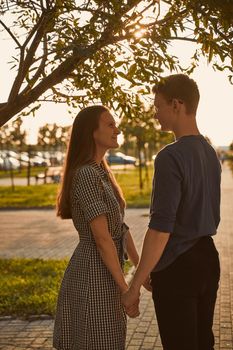 Boy and Girl holding hands in the park, concept of teen love, young couple